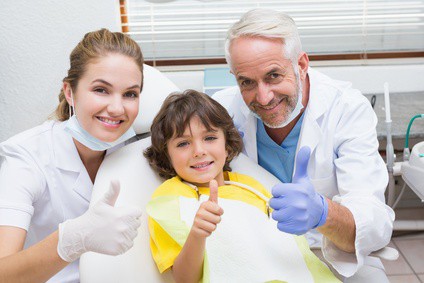 Pediatric dentist assistant and little boy all smiling